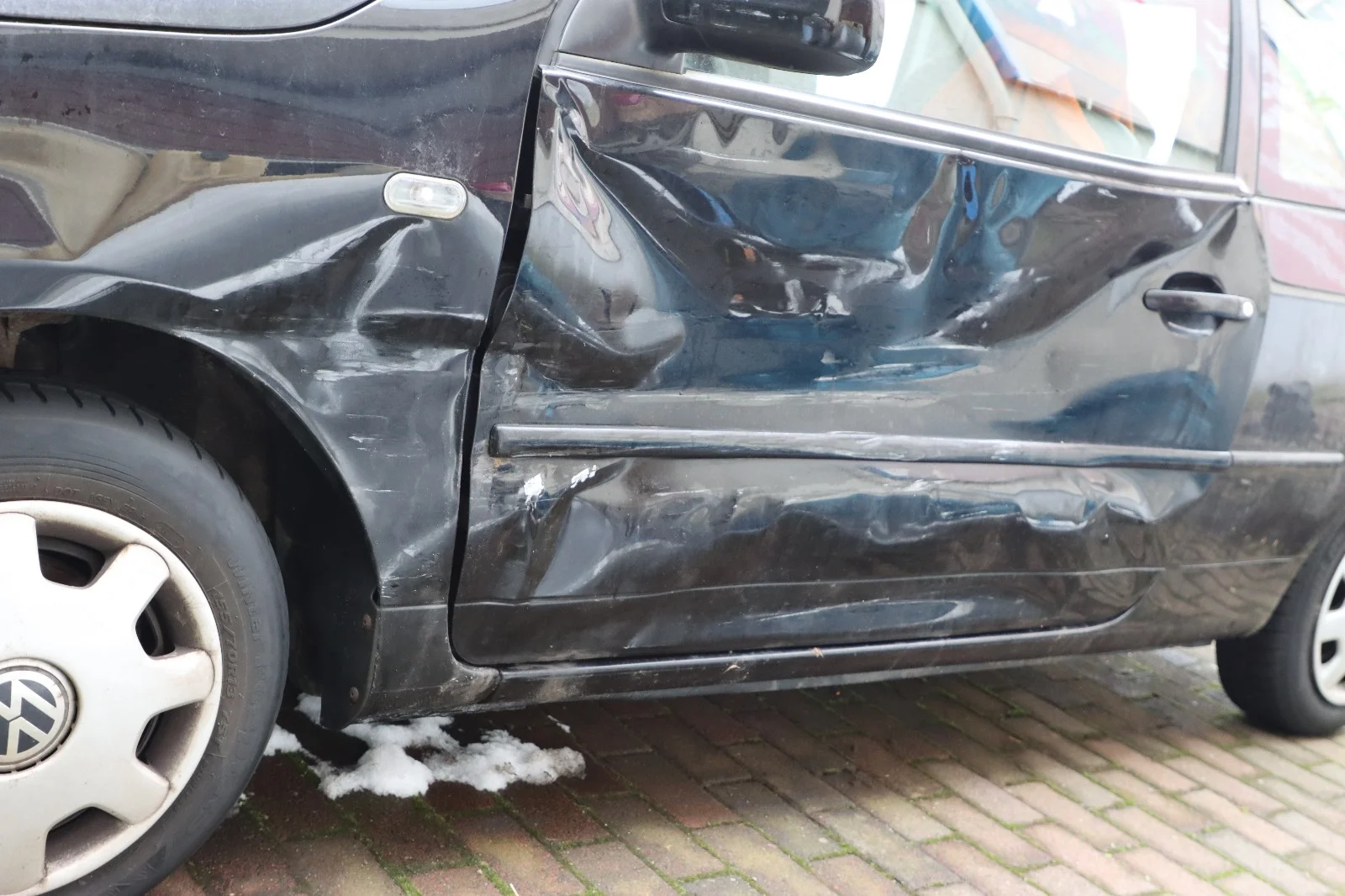Bild einer beschädigten Seite eines schwarzen Autos
